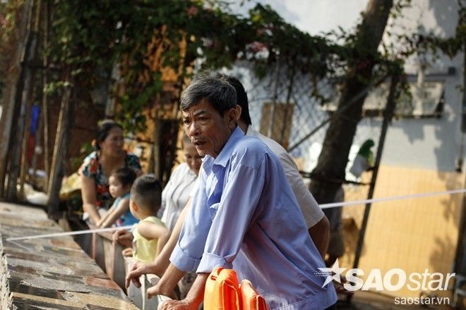 Người dân trên bờ bất lực nhìn các đối tượng bắt lại cá vừa thả dưới sông.