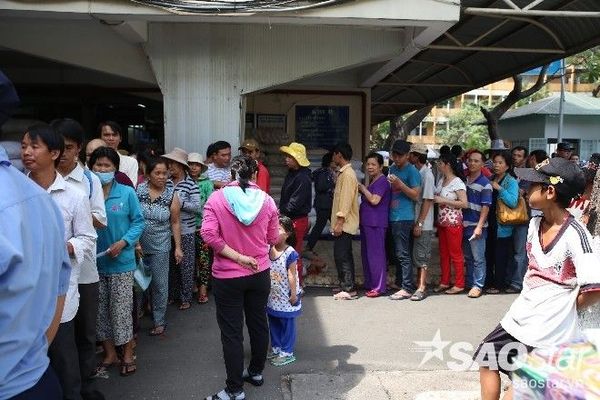 Bệnh nhân và người nhà vui mừng xếp hàng nhận quà.