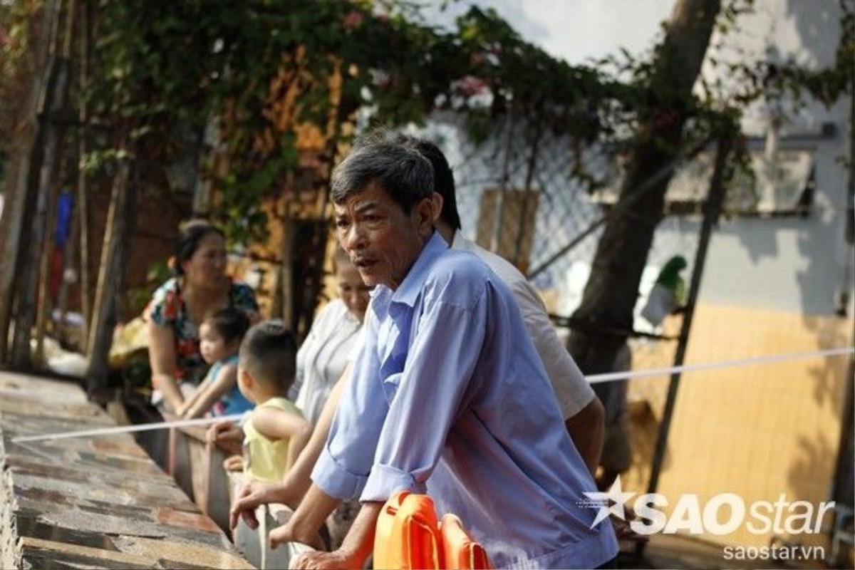 Người dân trên bờ bất lực nhìn các đối tượng bắt lại cá vừa thả dưới sông.